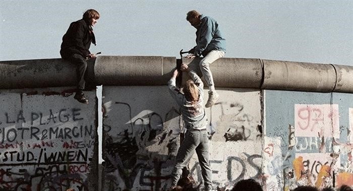 Жители Германской Демократической Республики активно демонтируют историческую Берлинскую стену в результате происходящих событий.